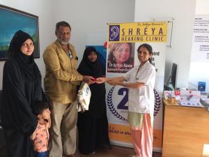 Patient receiving anniversary gift at Shreya Hearing Clinic